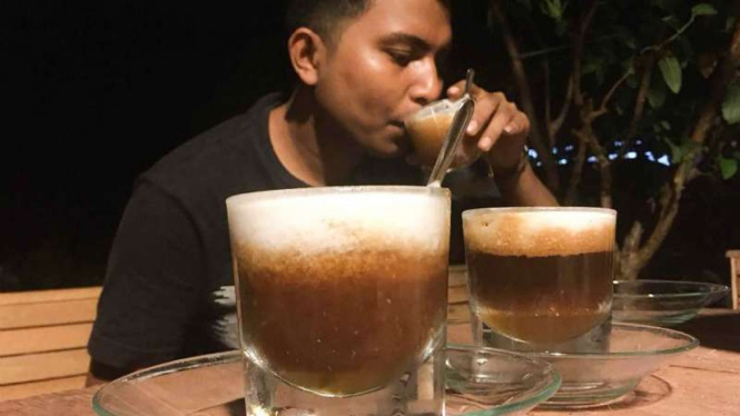 Seorang pengunjung Abu Master Coffee menikmati U-Presso, kopi arabik Aceh yang dicampur kelapa muda dan madu, di Banda Aceh, Aceh.