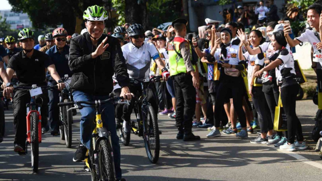 Presiden Joko Widodo menyapa warga ketika bersepeda 