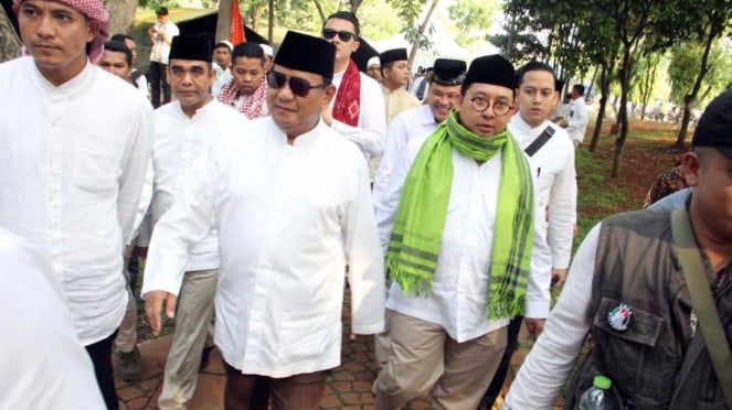 Calon presiden nomor urut 02, Prabowo Subianto (tengah) dan Fadli Zon (kedua kanan) jalan kaki ke lokasi Reuni 212 di Monas Jakarta.