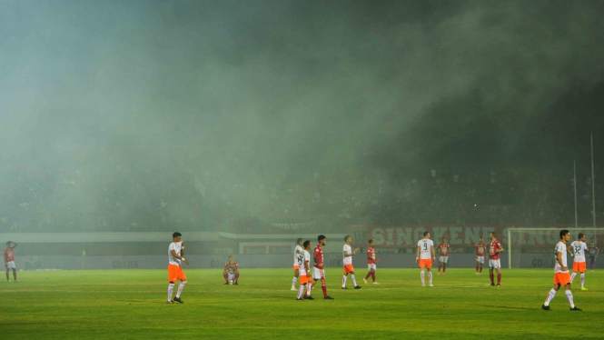 Pemain Bali United dan Persija Jakarta berada di lapangan saat gangguan asap kembang api yang dinyalakan oleh penonton pada pertandingan Sepak Bola Liga 1 antara Bali United melawan Persija Jakarta di Stadion I Wayan Dipta, Gianyar, Bali, Minggu, 2 Desemb
