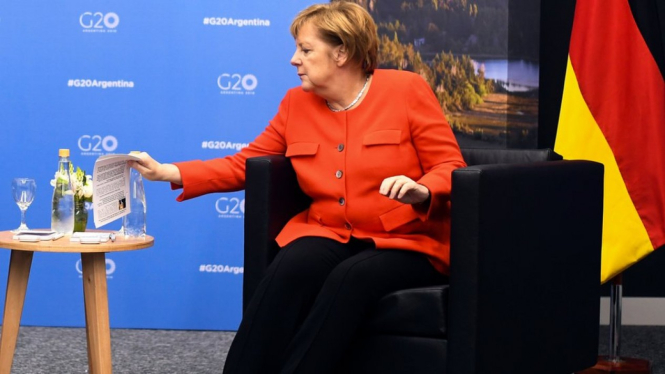 Angela Merkel reaches for a briefing note about Scott Morrison - EPA
