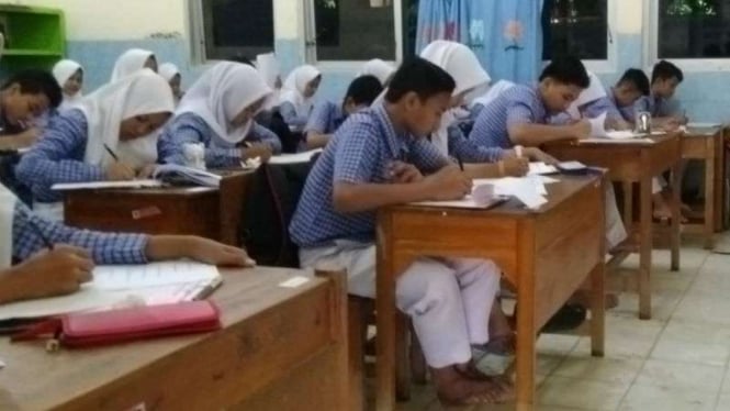 Siswa SMPN 34 Semarang ikuti ujian tanpa alas kaki gara-gara wilayah mereka terdampak banjir pada Selasa, 4 Desember 2018.