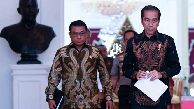 Presiden Joko Widodo (kanan) didampingi Kepala Staf Presiden Moeldoko saat bersiap memberikan keterangan pers di Istana Merdeka, Jakarta