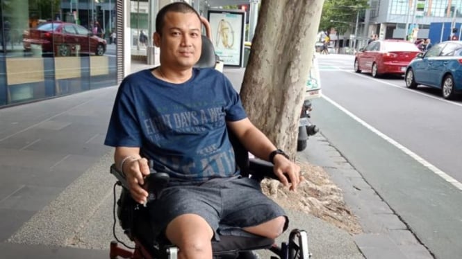 Ismail Marzuki di kursi roda listrik di depan hotelnya di Melbourne.