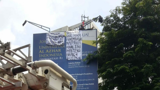 Agustinus panjat papan baliho kampus Al Azhar, Jakarta Selatan
