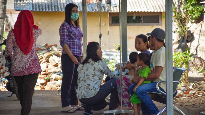 Sejumlah petugas merawat pasien di luar ruangan pasca terjadi gempa bumi di Puskesmas Malaka, Desa Malaka, Kecamatan Pemenang, Lombok Utara, NTB
