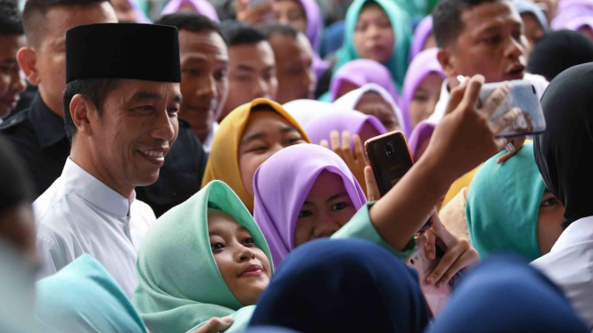 Presiden Joko Widodo (kiri) melakukan swafoto dengan mahasiswa ketika mengunjungi Universitas Aisyiyah di Yogyakarta