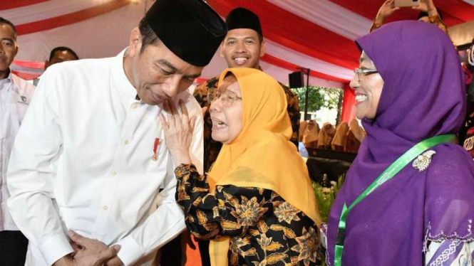 Presiden Joko Widodo dipeluk dan didoakan oleh seorang perempuan paruh baya istri mendiang tokoh terkemuka Muhammadiyah, Jasman Al Kindi, di Yogyakarta, Kamis, 6 Desember 2018.