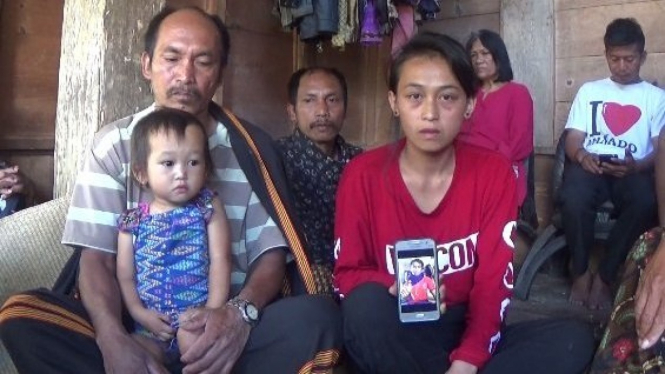 Anita Limbu Datu (ketiga dari kanan) menunjukkan foto Alpianus, suaminya. Ia tak percaya sang suami, salah satu pekerja PT Istaka Karya, tewas di tangan kelompok bersenjata Papua (5/12) - Jufri Tonapa untuk BBC News Indonesia