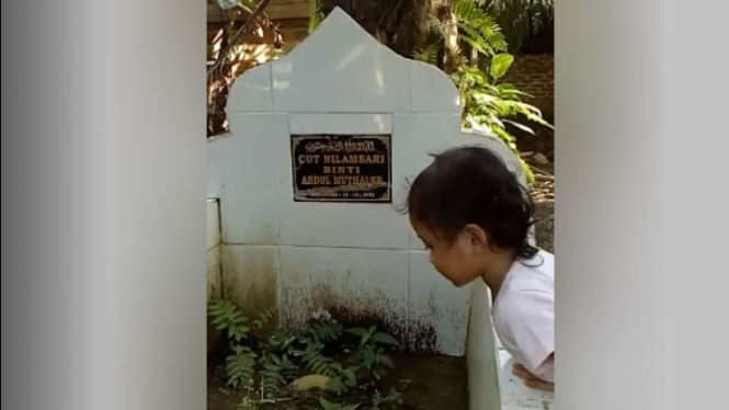 Gadis kecil di makam ibunya.