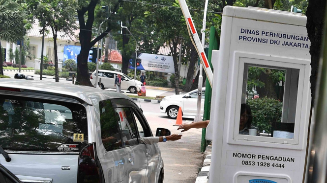 Pengendara mobil membayar parkir di lapangan IRTI Monas, Jakarta Pusat