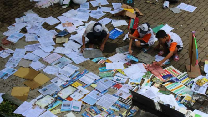 Siswa SMP Negeri 18 Kota Malang, Jawa Timur, menjemur buku dan dokumen penting sekolah setelah kompleks sekolah mereka kebanjiran Selasa, 11 Desember 2018.