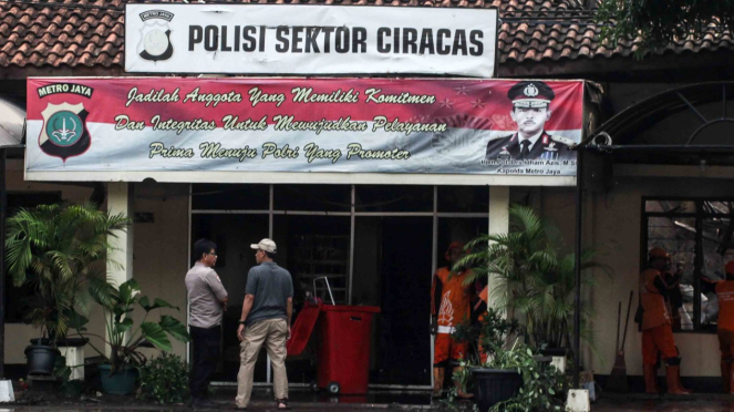 Petugas kepolisian beraktivitas usai perusakan dan pembakaran Polsek Ciracas, di Jakarta, Rabu, 12 Desember 2018.