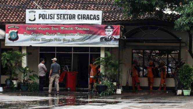 Petugas kepolisian beraktivitas usai perusakan dan pembakaran Polsek Ciracas, di Jakarta, Rabu, 12 Desember 2018.