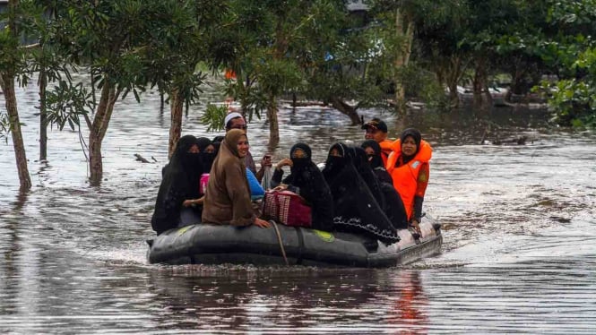 Petugas Basarnas menggunakan perahu karet mengevakuasi santri dan santriwati yang terjebak banjir di Pondok Pesantren Darul Ulum, Kecamatan Siak Hulu, Kabupaten Kampar, Riau