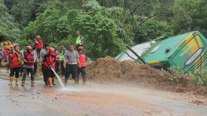 Aparat gabungan membersihkan material longsor untuk membuka akses jalan agar bisa dilintasi kendaraan bermotor di jalan lintas Sumatera rute Sitinjau Lauik di Padang, Sumatera Barat, Jumat, 14 Desember 2018.