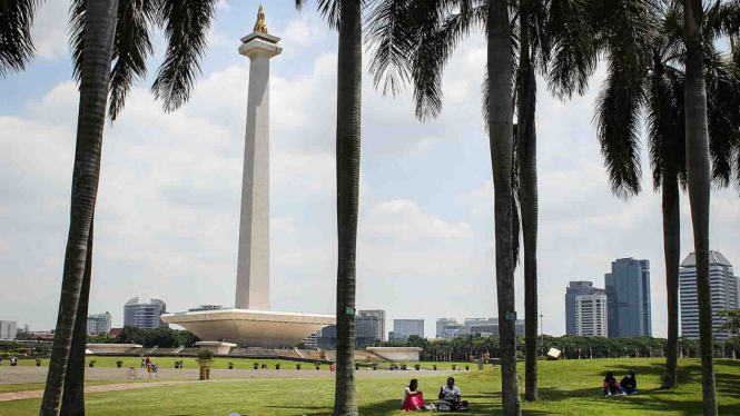 Pengunjung bersantai di taman Monumen Nasional (Monas), Jakarta.