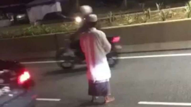 Seorang pria di Malaysia salat di tengah jalan.