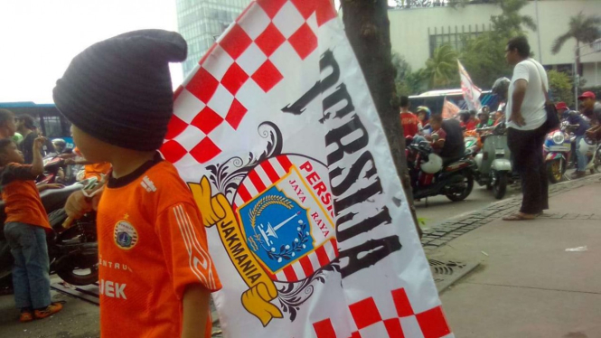Seorang anak kecil membawa atribut Persija Jakarta dalam perayaan gelar juara