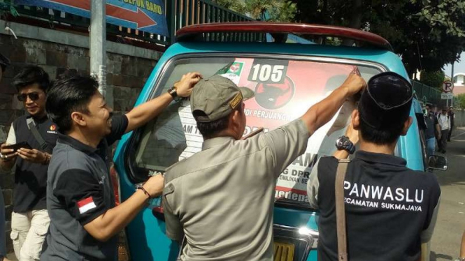 Petugas copot stiker kampanye di angkot, di Depok, Jawa Barat.