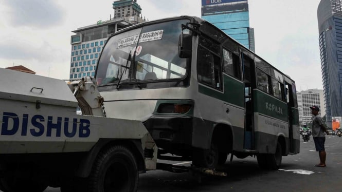 Dinas Perhubungan DKI Jakarta menderek bus Kopaja yang berhenti sembarangan saat mencari penumpang di Kawasan Cikini, Jakarta