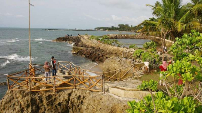 Pengunjung menyaksikan gelombang laut di Pantai Anyer beberapa waktu lalu