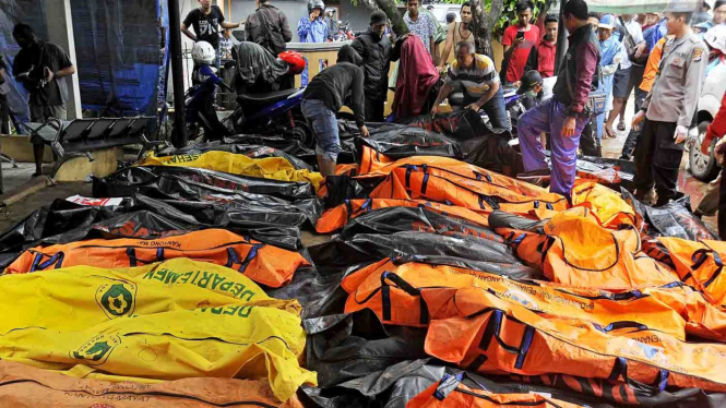 Sejumlah relawan mengumpulkan jasad korban meninggal dunia akibat gelombang tsunami untuk dievakuasi ke rumah sakit di Pantai Sembolo, Carita, Pandeglang, Banten, ke Puskesmas Labuhan