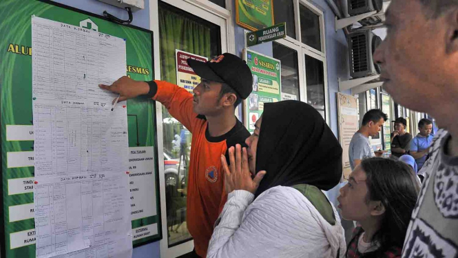 Warga melihat daftar korban meninggal tsunami di Selat Sunda untuk mencari informasi kerabatnya yang hilang di Puskesmas Carita Pandeglang, Banten, ke Puskesmas Labuhan