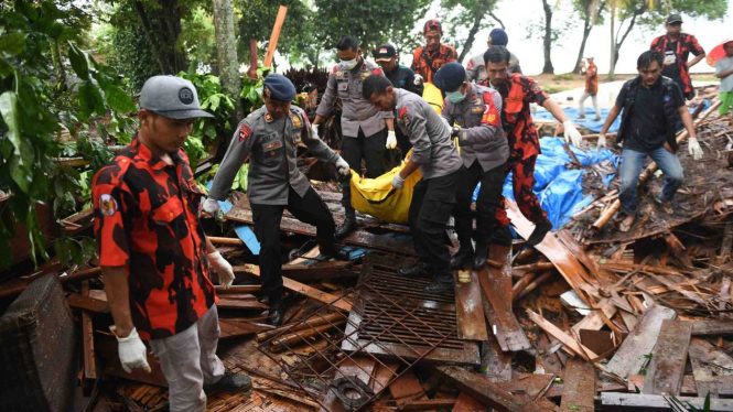 Polisi dan relawan mengevakuasi korban tewas akibat Tsunami yang tertimbun di bawah reruntuhan di kawasan Carita, Banten, Jawa Barat