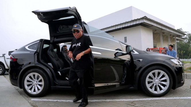 Menteri PUPR, Basuki Hadimuljono di depan mobil listrik Tesla.