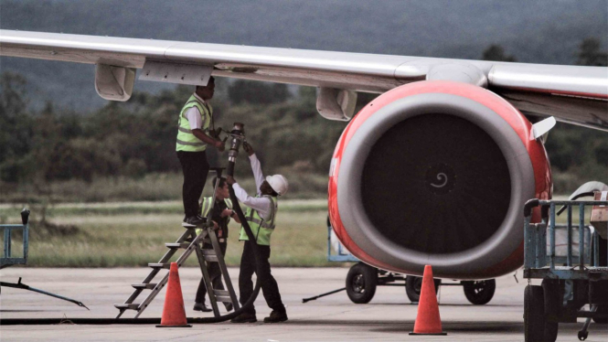 Petugas melakukan pengisian bahan bakar avtur pada salah satu pesawat di Bandara Udara.