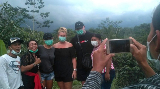 Turis asing berswafoto di depan Gunung Agung di Bali meski statusnya sudah `Awas`. - JULIO ALVARES