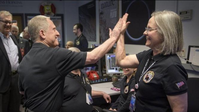 Ilmuwan Alan Stern dan Alice Bowman bersukacita setelah menerima sinyal dari New Horizons. - NASA HQ