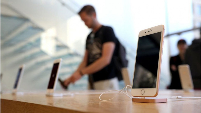 Seorang pengunjung menjajal produk ponsel pintar Apple beberapa waktu lalu.-Getty Images