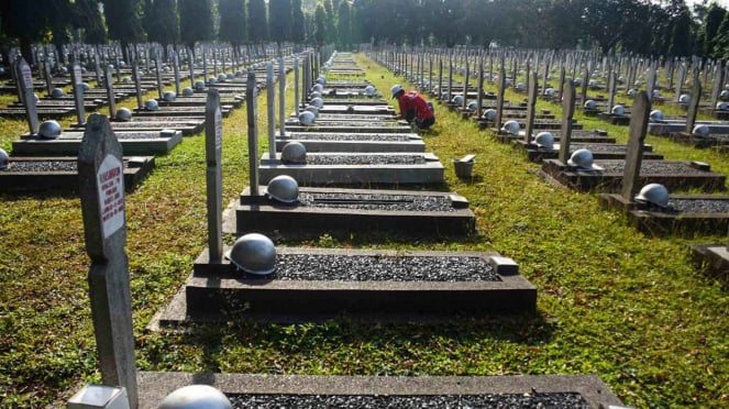 Trabalhadores consertam uma sepultura danificada pela queda de uma árvore no Cemitério dos Heróis de Kalibata, em Jacarta. (Foto ilustrativa).