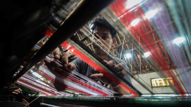 Pekerja menyelesaikan produksi kain sarung di Pabrik Tekstil Kawasan Industri Majalaya, Kabupaten Bandung, Jawa Barat, Jumat, 4 Januari 2019.