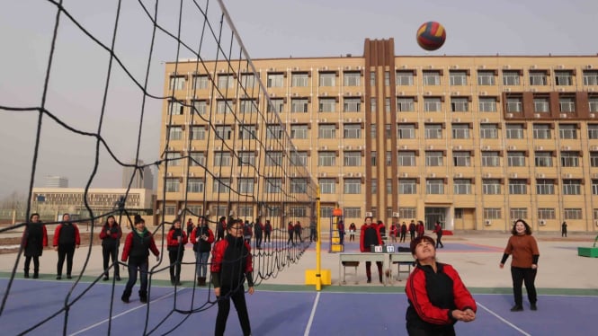 Para peserta didik kamp pendidikan vokasi etnis Uighur di Kota Kashgar, Daerah Otonomi Xinjiang, Cina, berolahraga di lapangan voli pelataran asrama, Jumat, 3 Januari 2019.