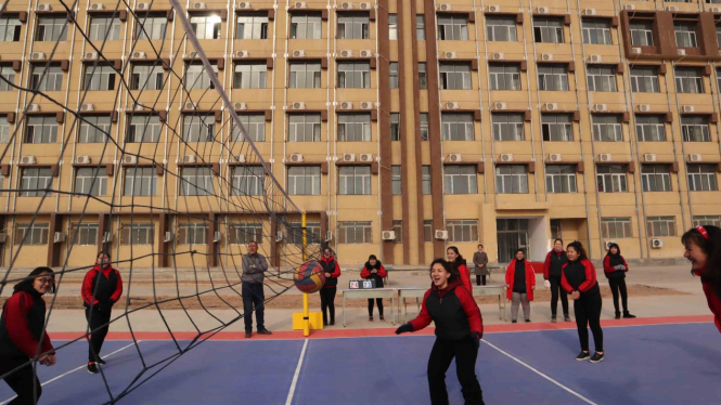 Para peserta didik kamp pendidikan vokasi etnis Uighur di Kota Kashgar, Daerah Otonomi Xinjiang, Cina, berolahraga di lapangan voli pelataran asrama, Jumat, 3 Januari 2019.