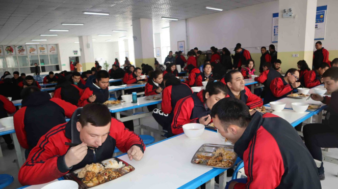 Para peserta didik kamp pendidikan vokasi etnis Uighur di Kota Kashgar, Daerah Otonomi Xinjiang, Cina, makan siang bersama dengan menu halal, di kantin, saat jam istirahat, Jumat, 3 Januari 2019.