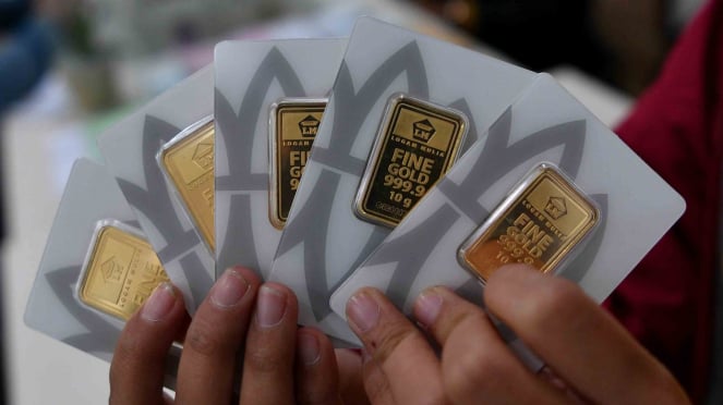 Konsumen menunjukkan emas batangan yang dibelinya di Butik Emas Logam Mulia, Gedung Aneka Tambang, Jakarta.