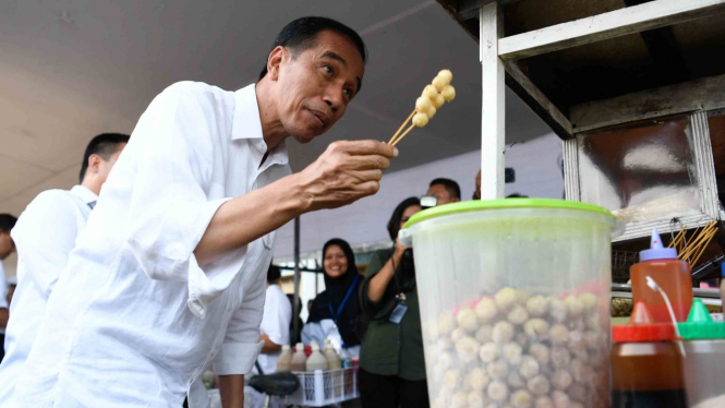 Presiden Joko Widodo membeli jajanan Cilok saat meninjau Program Mekaar binaan PNM di Cijantung, Jakarta