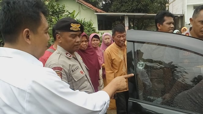 Polisi menunjukan kaca mobil bekas tembakan 