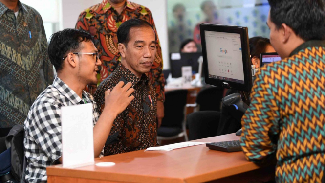 Presiden Joko Widodo (tengah) berbincang dengan masyarakat ketika meninjau layanan konsultasi Online Single Submission (OSS) BKPM di PTSP BKPM Jakarta