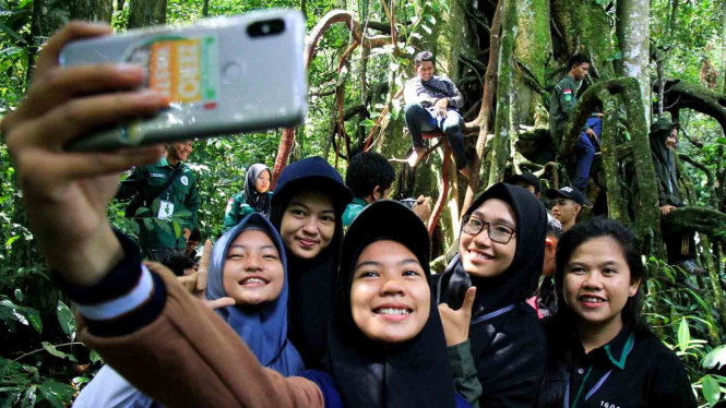 Berswafoto atau selfie menggunakan smartphone.