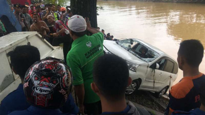Daihatsu Xenia terjun bebas di banjir kanal, Kota Padang, Sumatera Barat. 