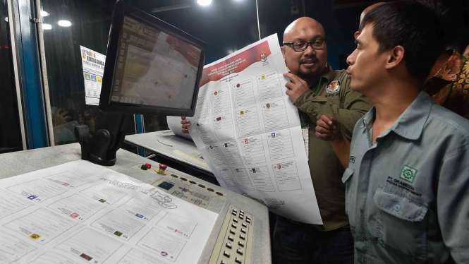Komisioner KPU Ilham Saputra (kiri) melakukan pemeriksaan kualitas warna surat suara legislatif saat proses pencetakan, di Jakarta