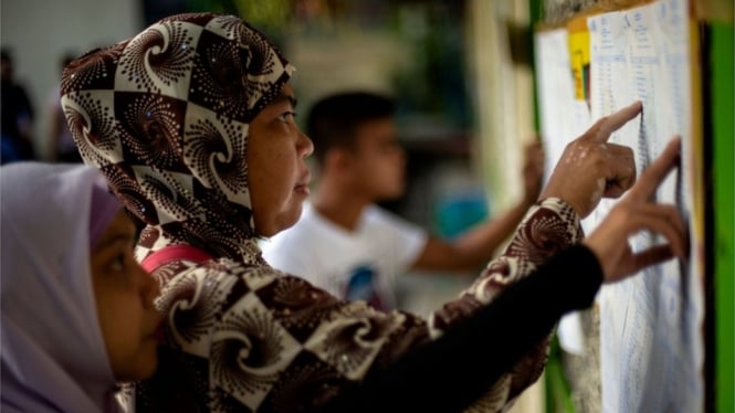 Sejumlah orang memeriksa nama mereka pada daftar pemilih referendum di Maguindanao, bagian selatan Pulau Mindanao, Filipina, Senin (21/1). - AFP/Getty Images