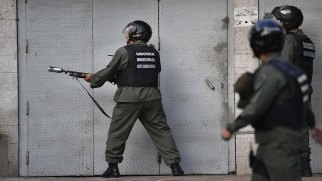 Anggota Garda Nasional menembakkan gas air mata ke arah warga Venezuela di Caracas yang berdemonstrasi setelah tersiar kabar terjadi pemberontakan terhadap Presiden Nicolas Maduro.-AFP