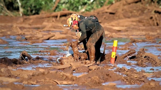 Sejumlah anggota regu penyelamat berupaya menarik tubuh seseorang dari timbunan lumpur setelah bendungan jebol di dekat Kota Brumadinho, Brasil.-EPA