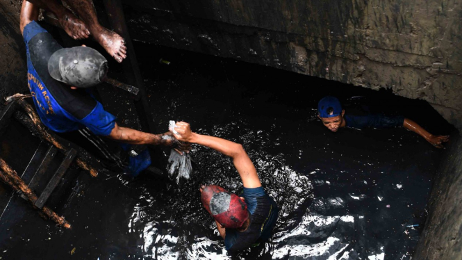 Sejumlah petugas Dinas Tata Air Provinsi DKI Jakarta membersihkan sampah dan lumpur di gorong-gorong Protokol MH Thamrin, Jakarta, Senin, 28 Januari 2019.